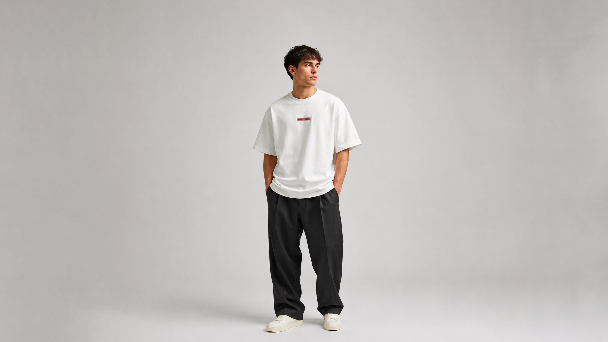 Model wearing Nous Le Faisons premium streetwear in a clean editorial setting